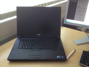 Dell Notebook auf Schreibtisch neben Monitor